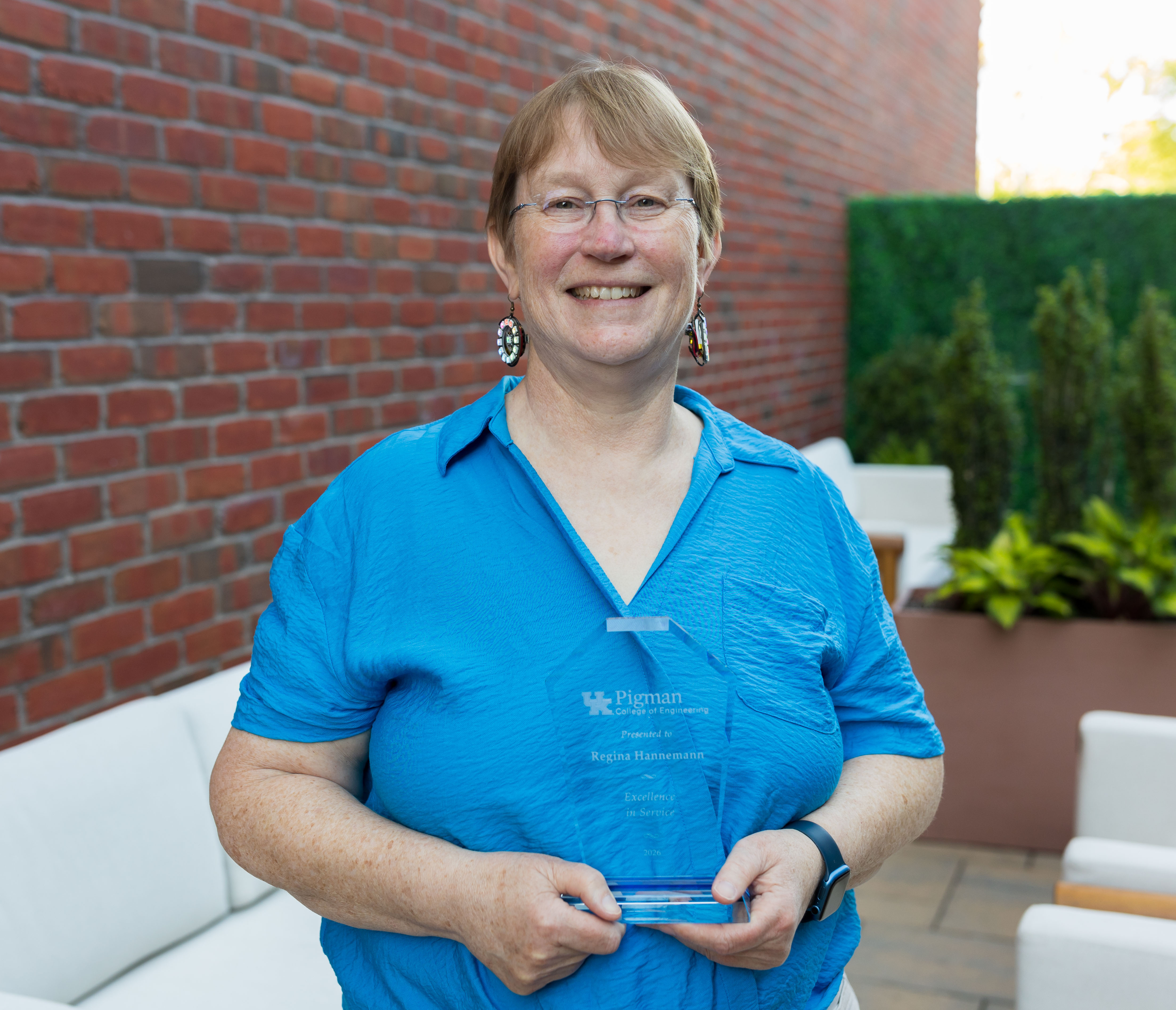 Regina Hannemann holding 2026 Faculty Award outside 