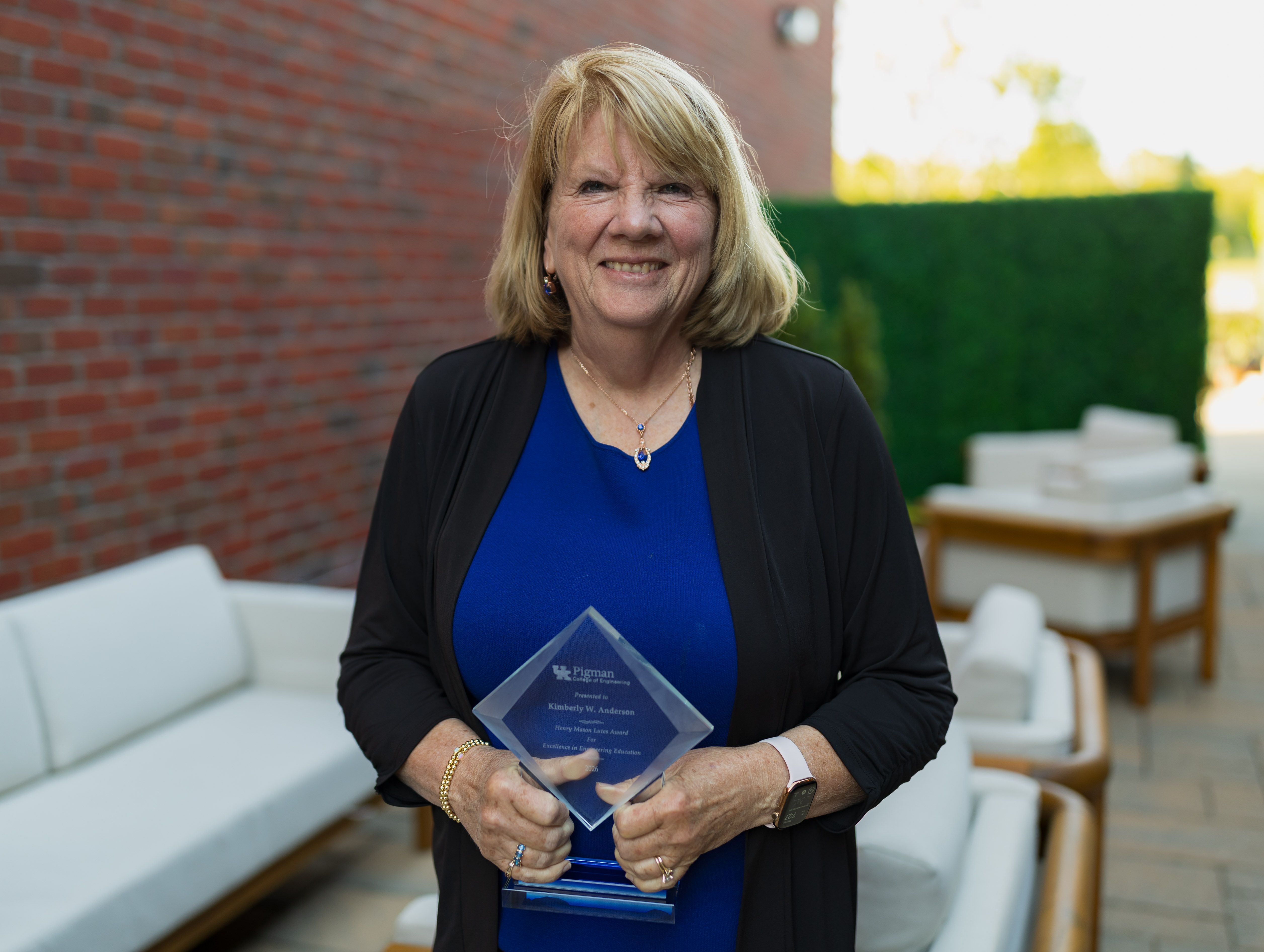 Kimberly Anderson holding 2026 Faculty Award outside 