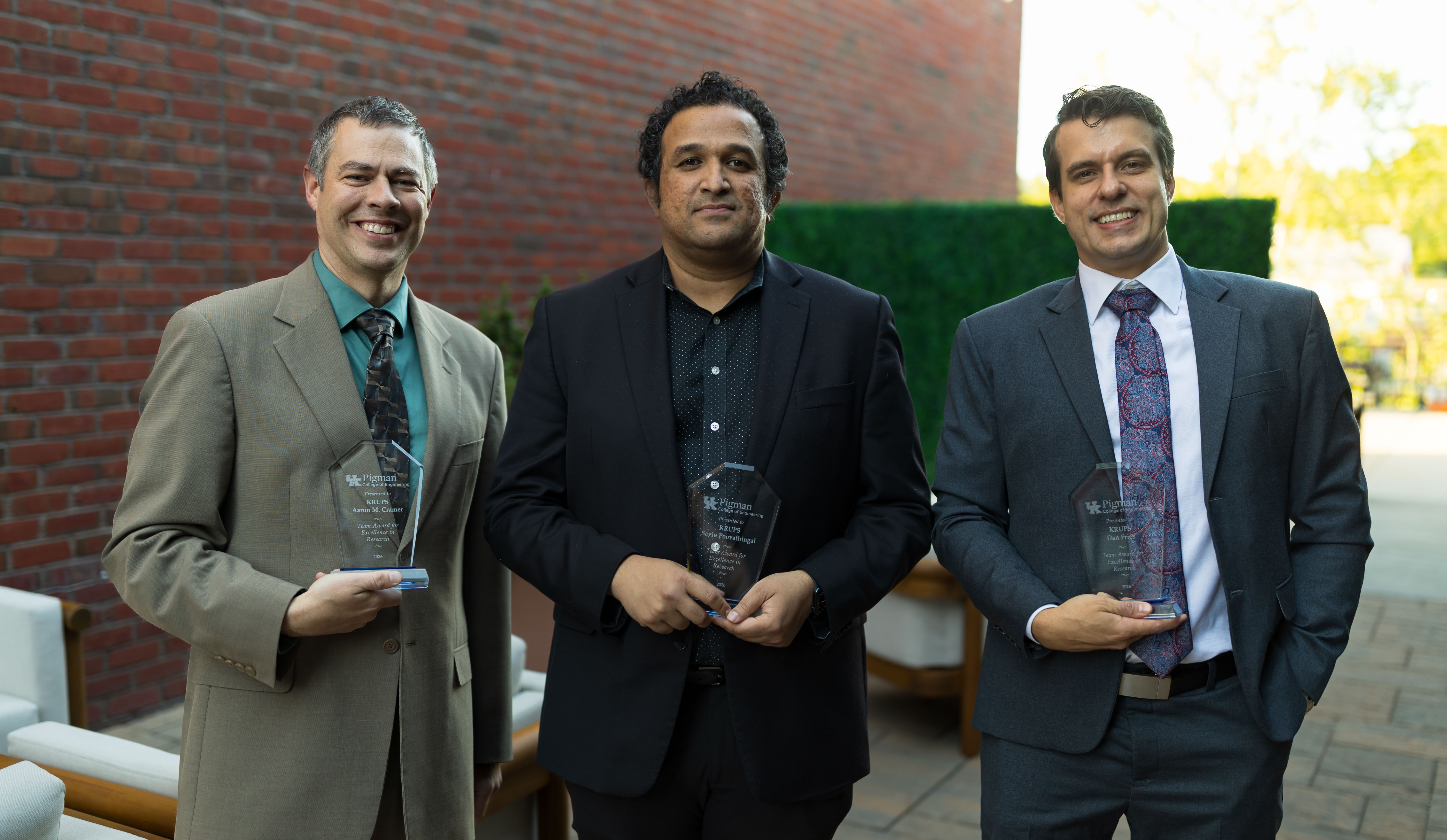 KRUPS team members Aaron Cramer, Savio Poovathingal and Dan Fries holding 2026 Faculty Awards outside
