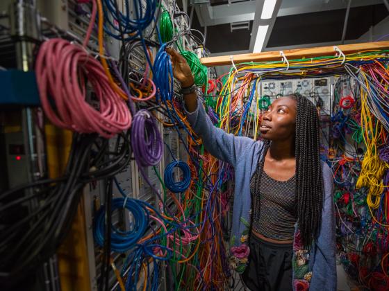 Student surrounded by computer ethernet cables.