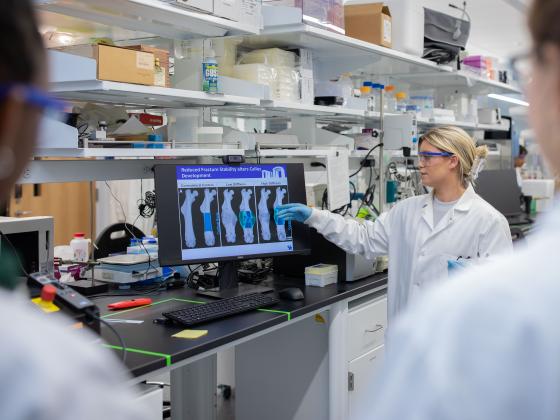 Person in lab pointing at screen